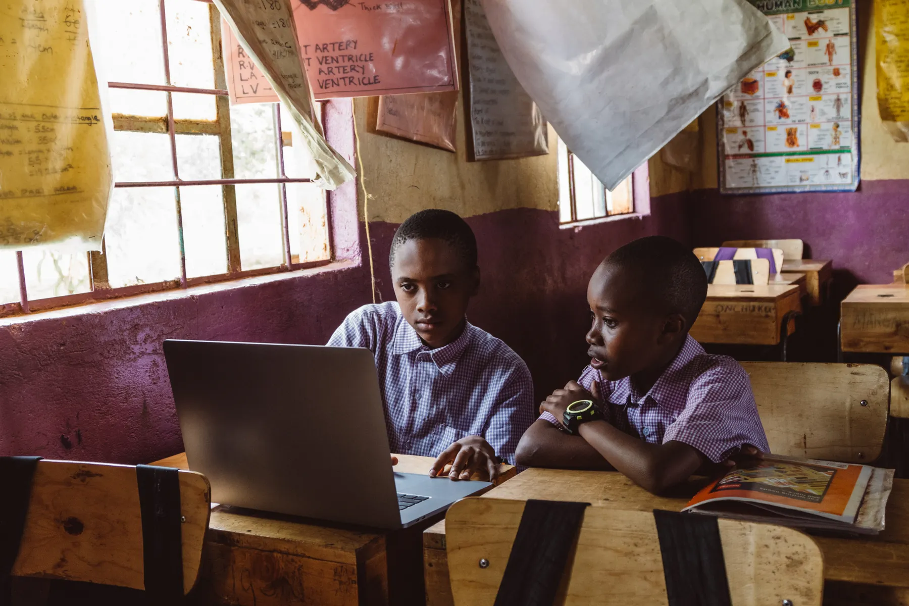 Students collaborating on a laptop during a classroom lesson